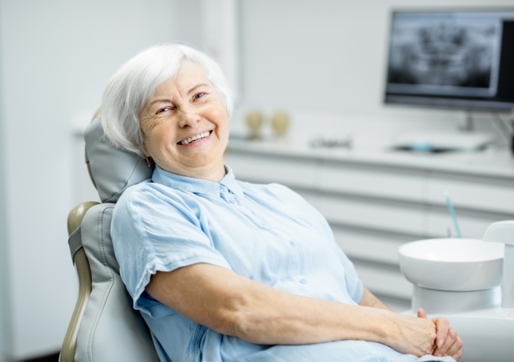 Senior woman smiling while sitting in dental chair