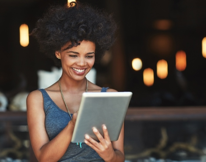 Woman smiling while scrolling on a tablet