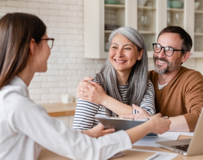 Couple smiling at person sitting across table from them