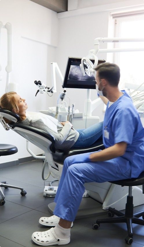 Dentist talking to a patient in the treatment chair