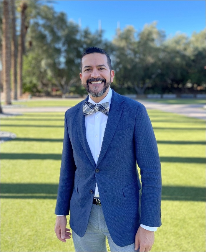 Naples surgical prosthodontist Doctor Randold Binns smiling outdoors in a suit