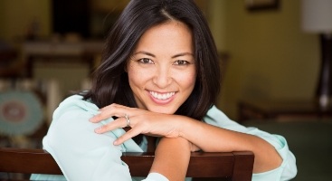 Woman smiling while leaning over the back of her chair