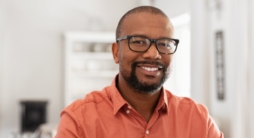 Smiling man in glasses and orange button down shirt