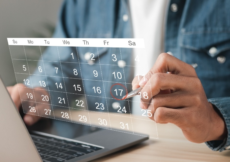 Person circling the date of a dental appointment on a calendar