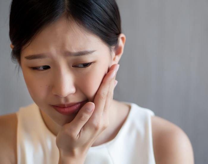 Woman holding the side of her face in pain